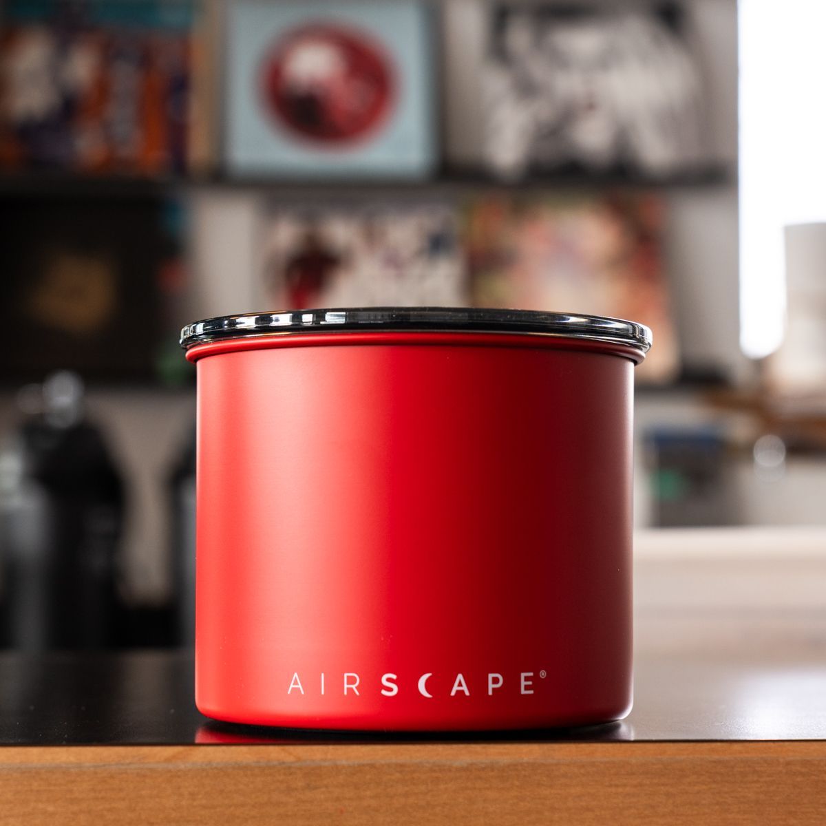 Red airscape container on a wooden surface with a blurred background