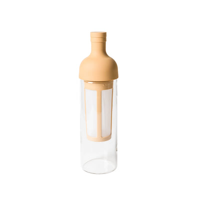 Clear glass bottle with beige lid and base on a white background