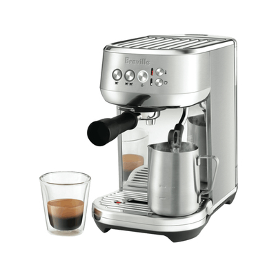 Stainless steel espresso machine with Breville branding, angled profile with espresso in a glass cup in front