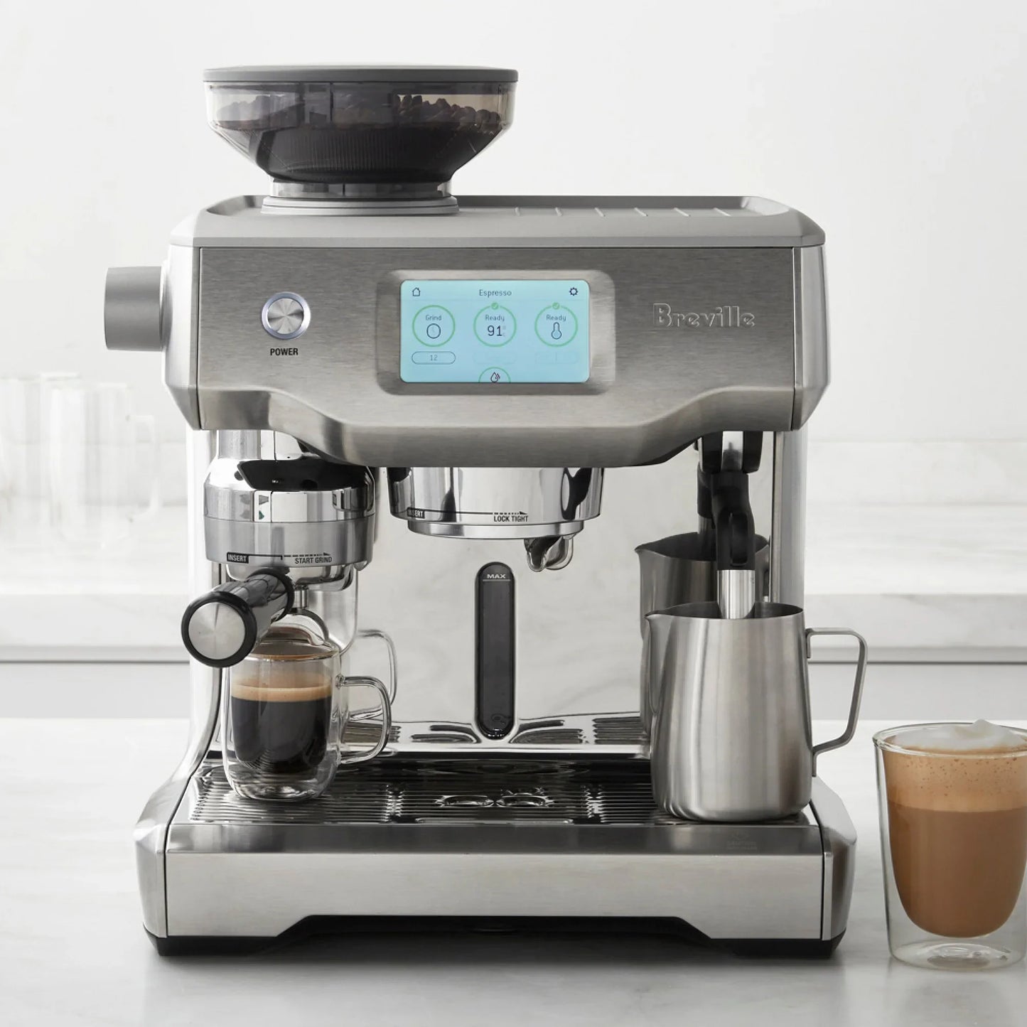Breville coffee machine with two glasses of coffee on a white surface