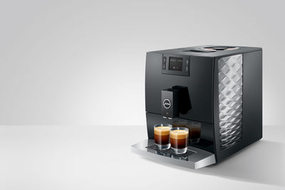 Modern coffee machine with two cups of coffee on a white background