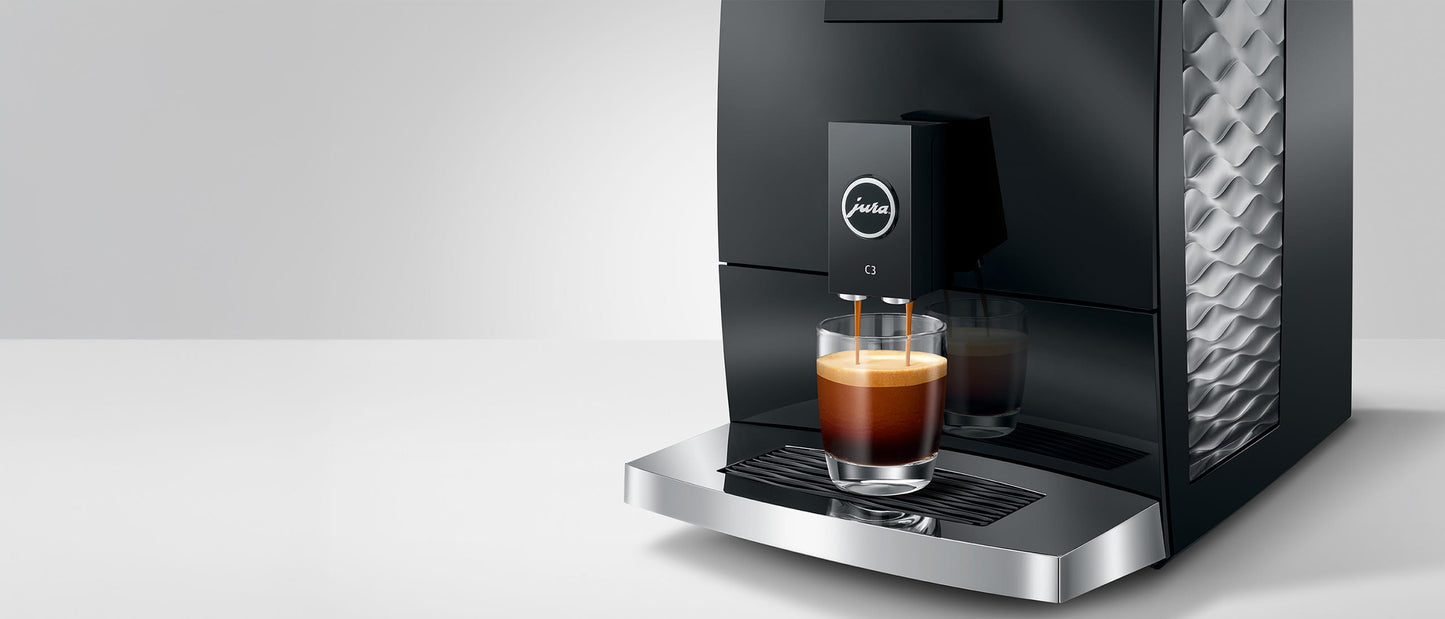 Jura C3 coffee machine with a glass of coffee on a white background