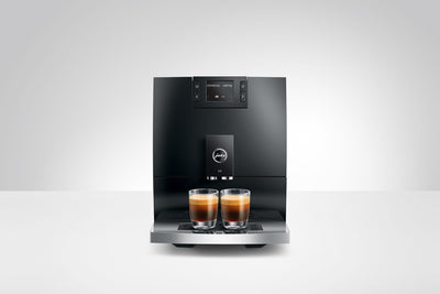 Modern coffee machine with two glasses of coffee on a white background