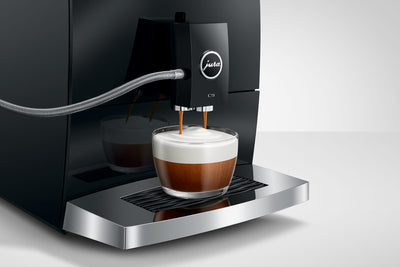Jura coffee machine dispensing a cup of coffee with a white background