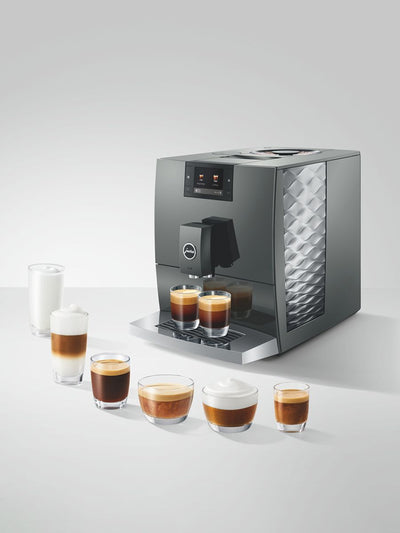 Modern coffee machine with various coffee beverages on a white surface