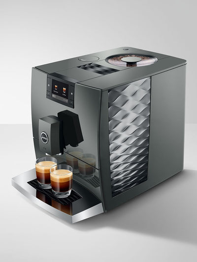 Modern coffee machine with two glasses of coffee on a light gray background