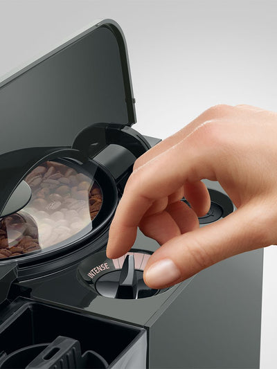 Hand interacting with a coffee machine, focusing on the brand 'Nespresso'.