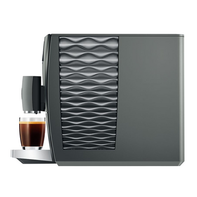 Gray coffee machine with a glass of coffee on a white background