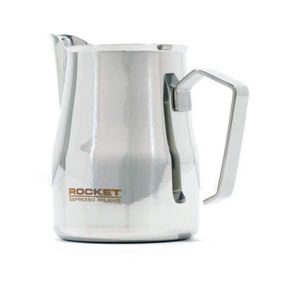 A polished stainless steel milk pitcher with a curved handle and spout, featuring the 'ROCKET ESPRESSO MILANO' logo printed in gold on the front, set against a plain white background.