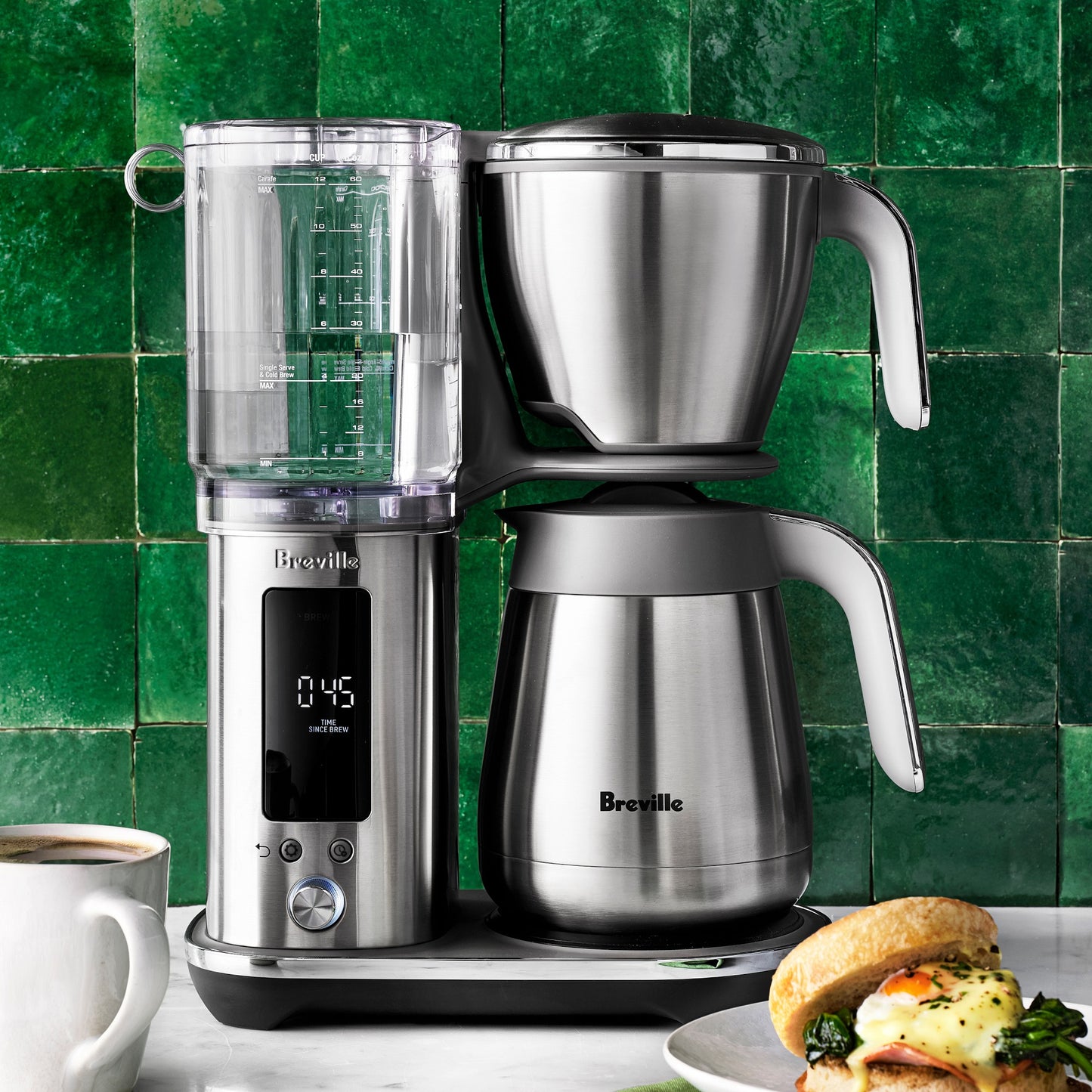 Breville - The Luxe Brewer Drip Coffee Maker - BDC415BSS / BDC465BSS with digital display on a kitchen counter with a green tiled wall background.