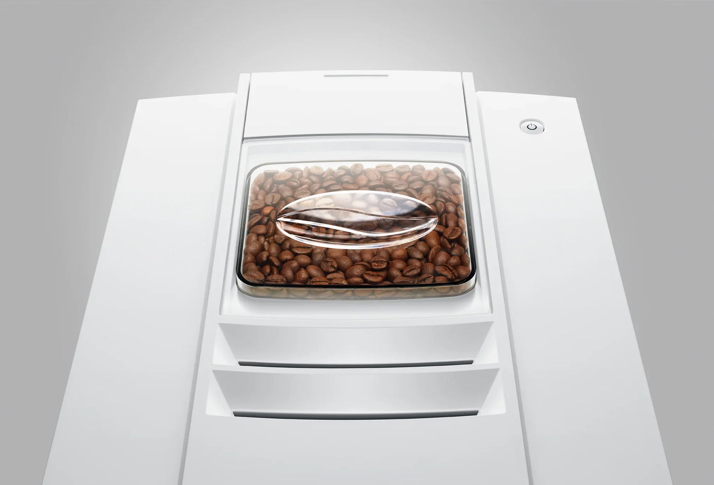 White coffee machine with a clear lid showing coffee beans on a gray background