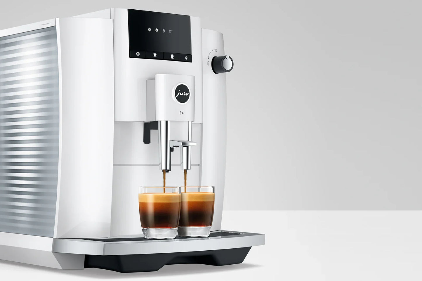 White coffee machine dispensing two cups of coffee on a light gray background