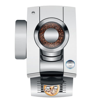 A sleek, modern espresso machine in polished silver stainless steel with a transparent bean hopper showing roasted coffee beans, set against a solid white background.